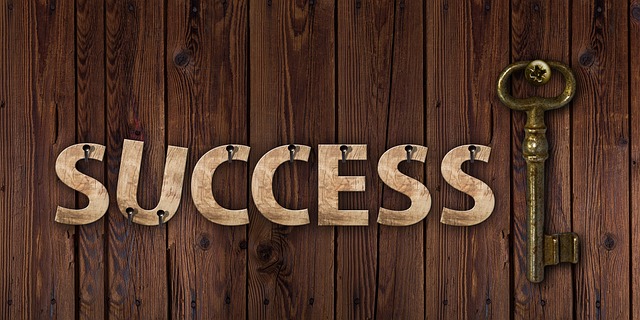 the word success with a key beside it, set against a wooden backdrop
